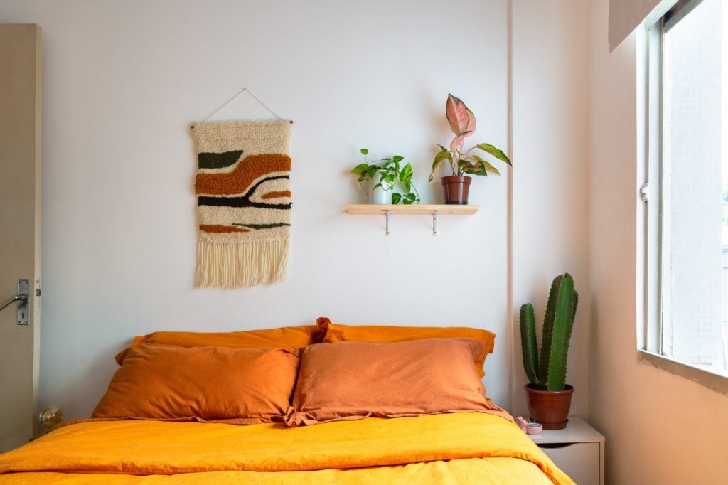Foto que ilustra matéria em parceria com o blog “Histórias de Casa” sobre apartamento na rua General Jardim mostra o quarto da moradora, com uma parte da cama e decorações na parede.