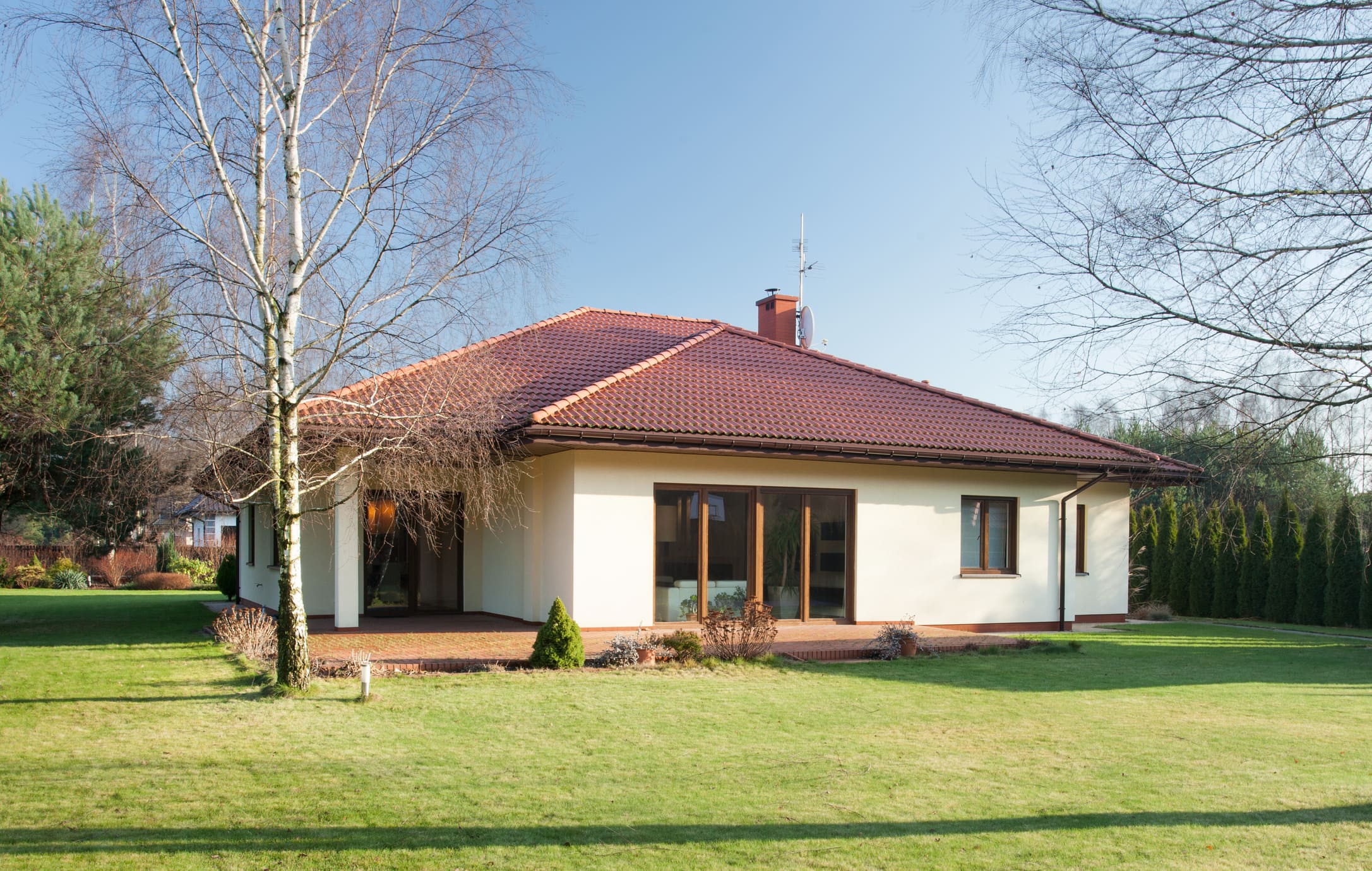 casa com telhado triangular e grama do lado de fora