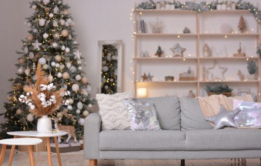 Sala de estar moderna decorada para o Natal em tons neutros com árvore e enfeites.