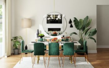 foto tirada mostra o reflexo da sala de jantar, pelo espelho redondo preso na parede. Há uma mesa e seis cadeiras, três em cada lado. Na parede aos lados do espelho há plantas.