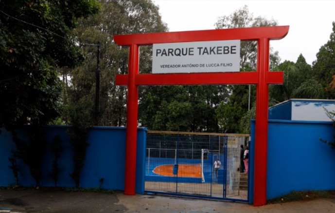 Foto que ilustra matéria sobre parque em Diadema mostra a entrada do Parque Takebe: um muro azul com um portal vermelho de estilo japonês emoldurando uma grade.