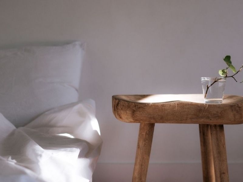cama e mesa de madeira autêntica com vaso de vidro nela