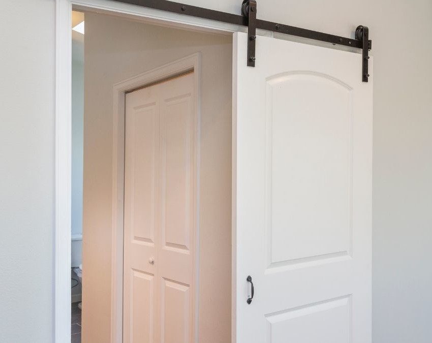 imagem mostra porta de correr branca, separando dois cômodos da casa