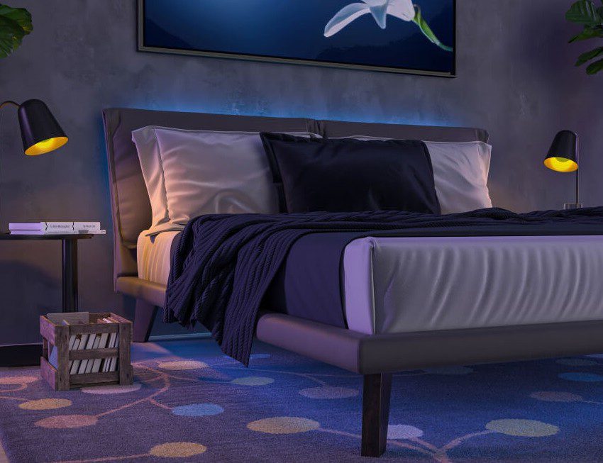 Foto que ilustra matéria sobre quarto neon mostra uma cama feita, com uma uma luz neon azul que aparece por detrás da cabeceira.