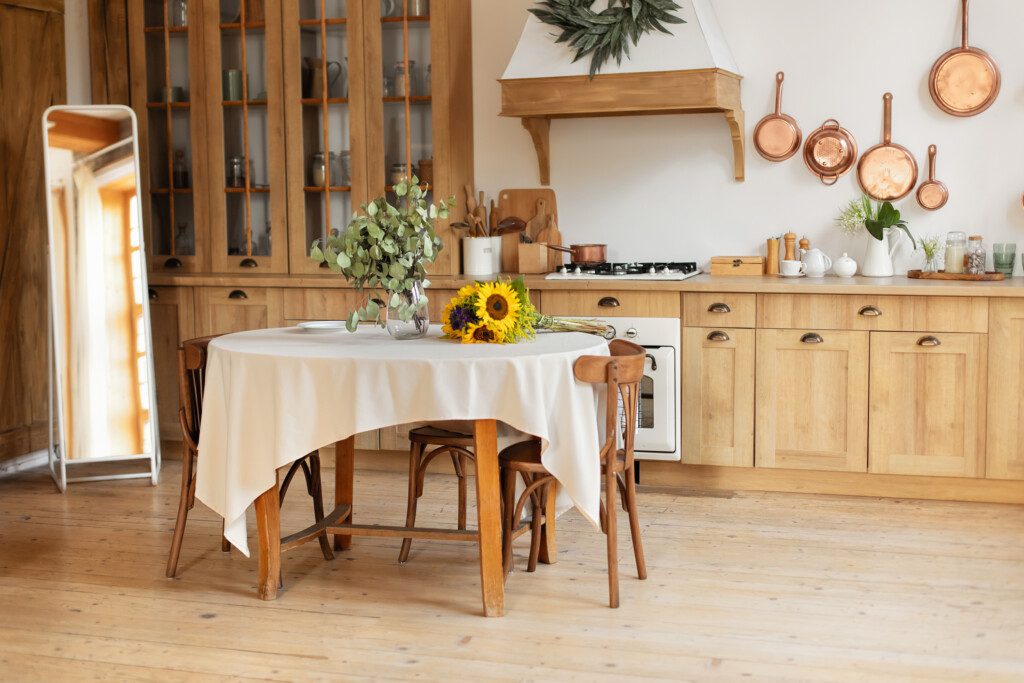 Elegante sala de jantar com móveis em estilo retrô de madeira aconchegante. Há também utensílios de cozinha, pratos, pratos, mesa redonda e cadeiras.