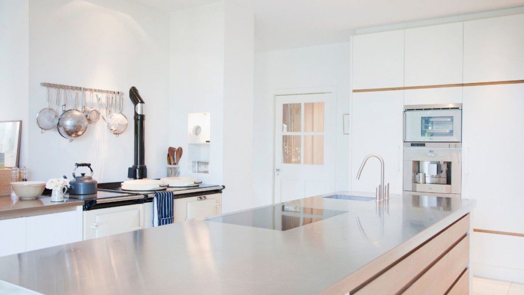 imagem de um balcão de cozinha de inox em uma cozinha extremamente clara