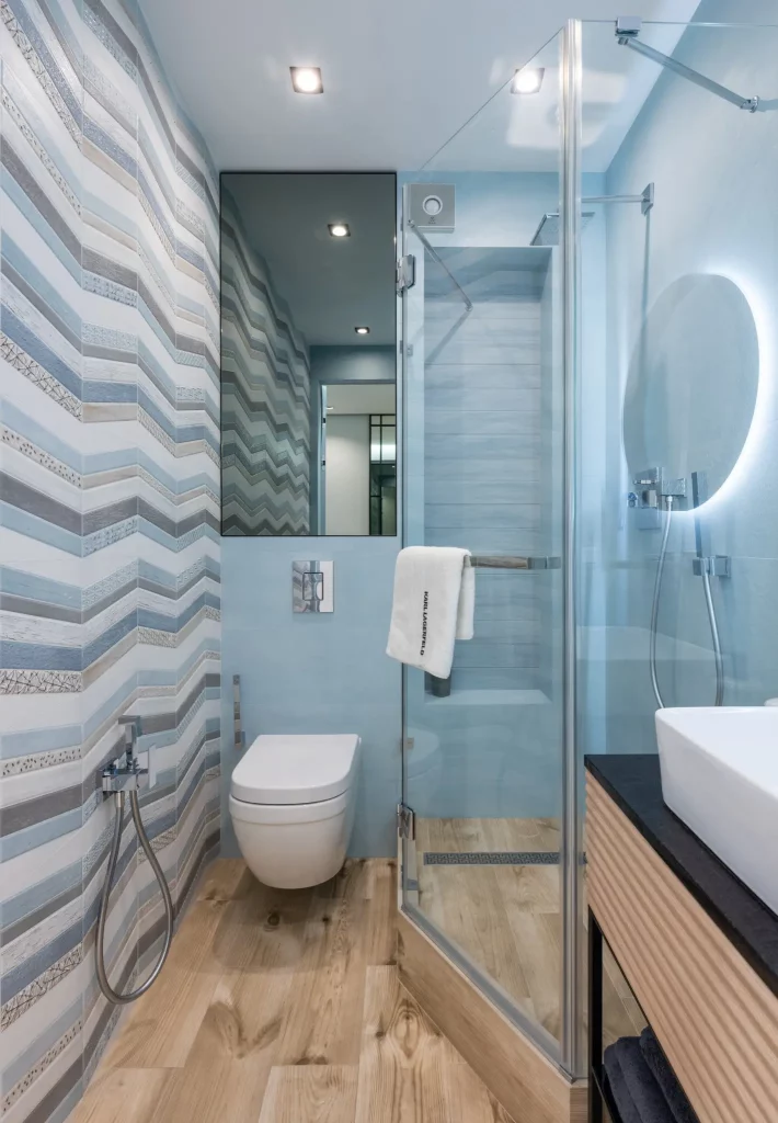 Foto de banheiro pequeno decorado com papel de parede azul claro com listras na horizontal. 