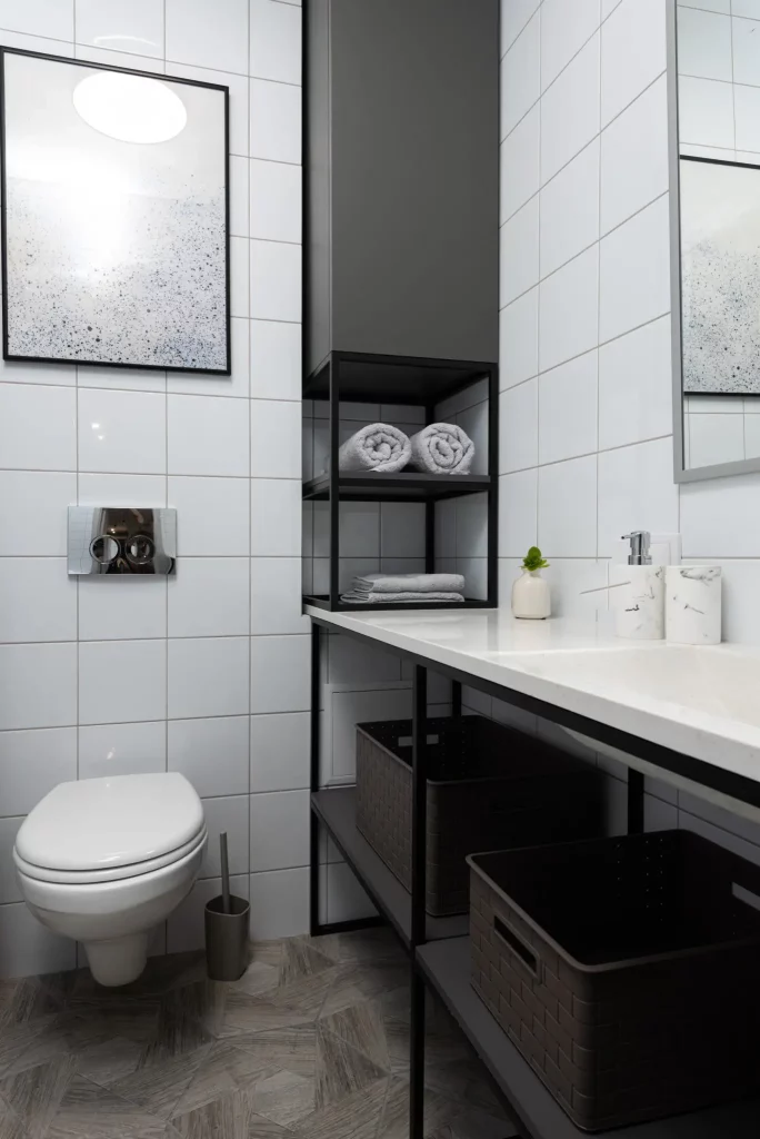 Foto de um banheiro minimalista com quadro decorativo em cima do vaso sanitário com desenho abstrato nas cores preto e branco.
