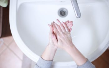 Foto que ilustra matéria sobre crise hídrica e energética em condomínios mostra duas mãos se lavando em uma pia