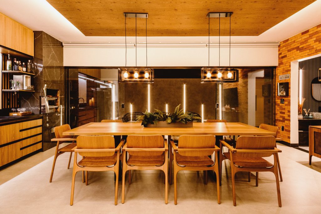 Sala de jantar com conjunto de mesa e cadeiras integrada a cozinha da casa.