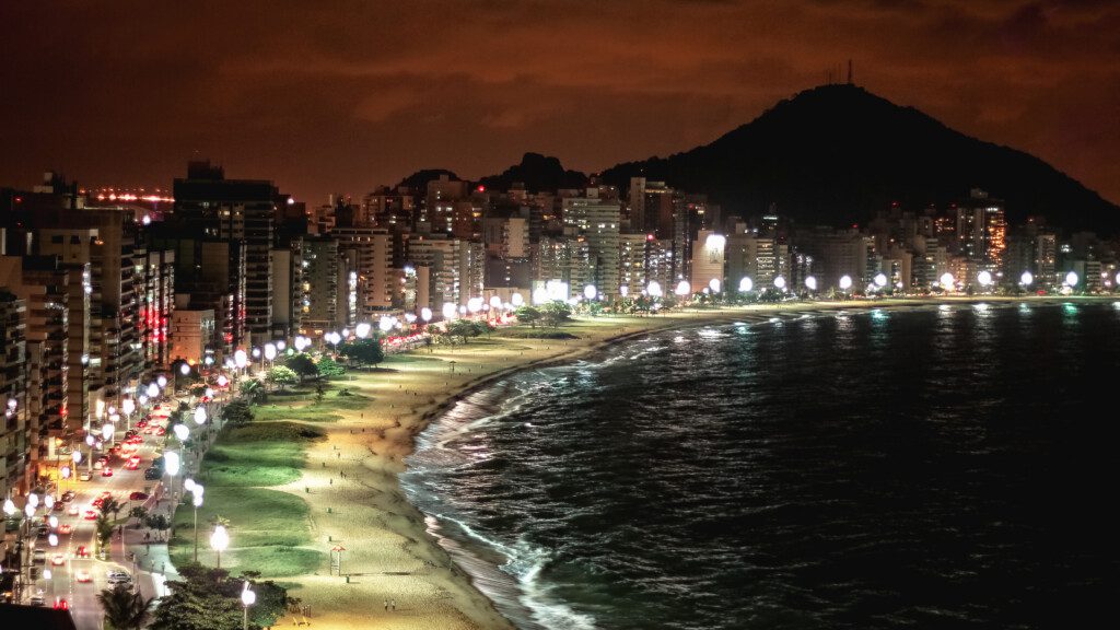 Imagem que ilustra matéria sobre o que fazer em Vitória mostra vista panorâmica da praia da cidade a noite