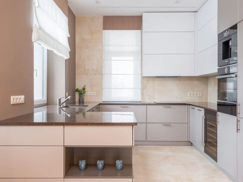 cozinha pequena em tons bege e rosados, com armários formando um quadrado central ao redor da área de cozinhar