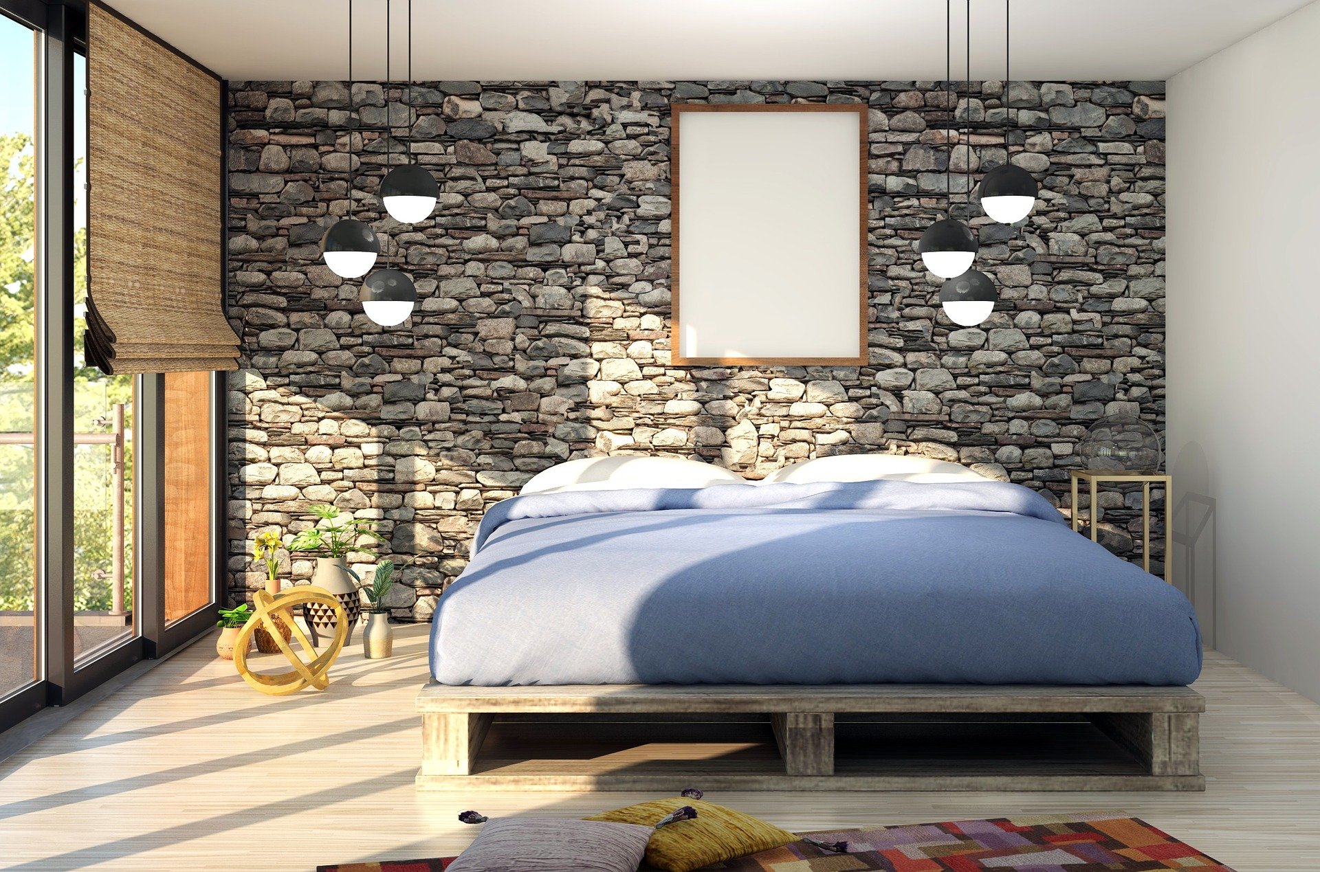 Imagem de um quarto pequeno totalmente decorado. A colchão da cama está em cima de pallets de madeira, a parede do fundo é com pedras e possui luminárias penduradas no teto. 