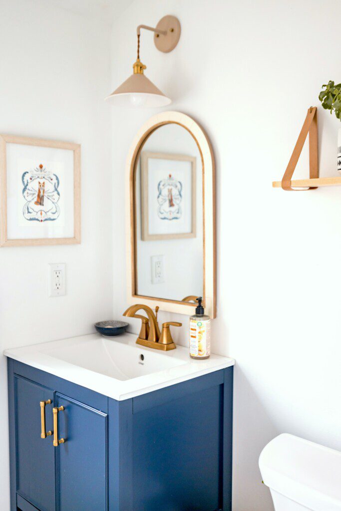 Lavabo com armário azul com detalhes em ferragens gold.