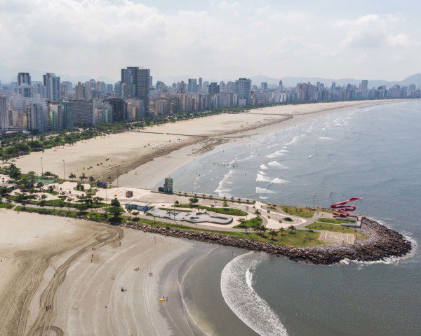 Foto que ilustra matéria sobre o que fazer em Santos mostra uma imagem panorâmica da orla da cidade, com destaque para o Parque Municipal Roberto Mário Santini, no Novo Quebra-Mar