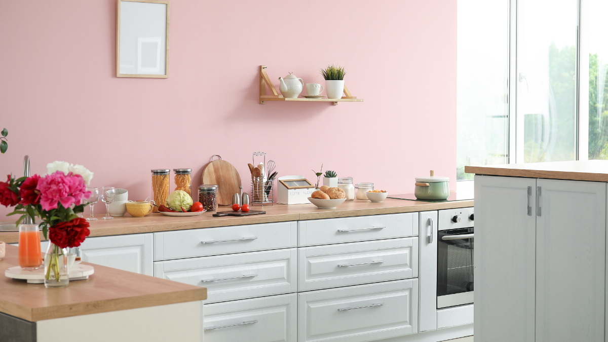 cozinha com bancadas brancas e paredes rosa