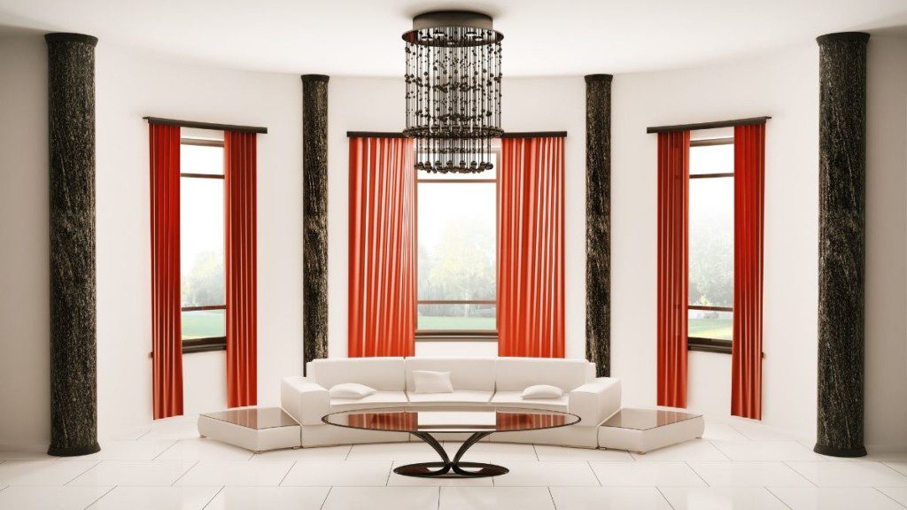 sofá curvo branco em espaço amplo, com cortinas vermelhas e paredes brancas