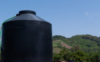 Imagem de uma cisterna grande na cor preta ao ar livre.