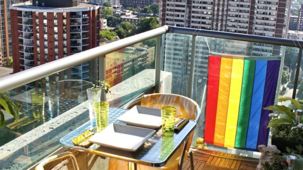 varanda com bandeira colorida, mesa com dois lugares e dois pratos e duas taças
