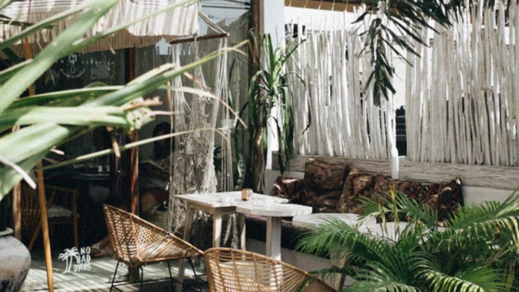 ambiente externo de uma casa de praia com decoração criativa, tecidos e plantas