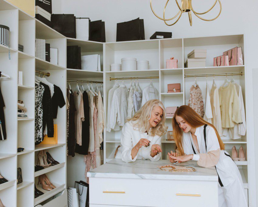 Imagem de duas mulheres escolhendo acessórios no closet.