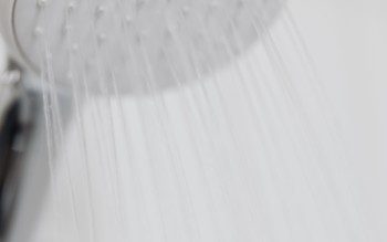 Imagem de um chuveiro com gotas de água caindo.
