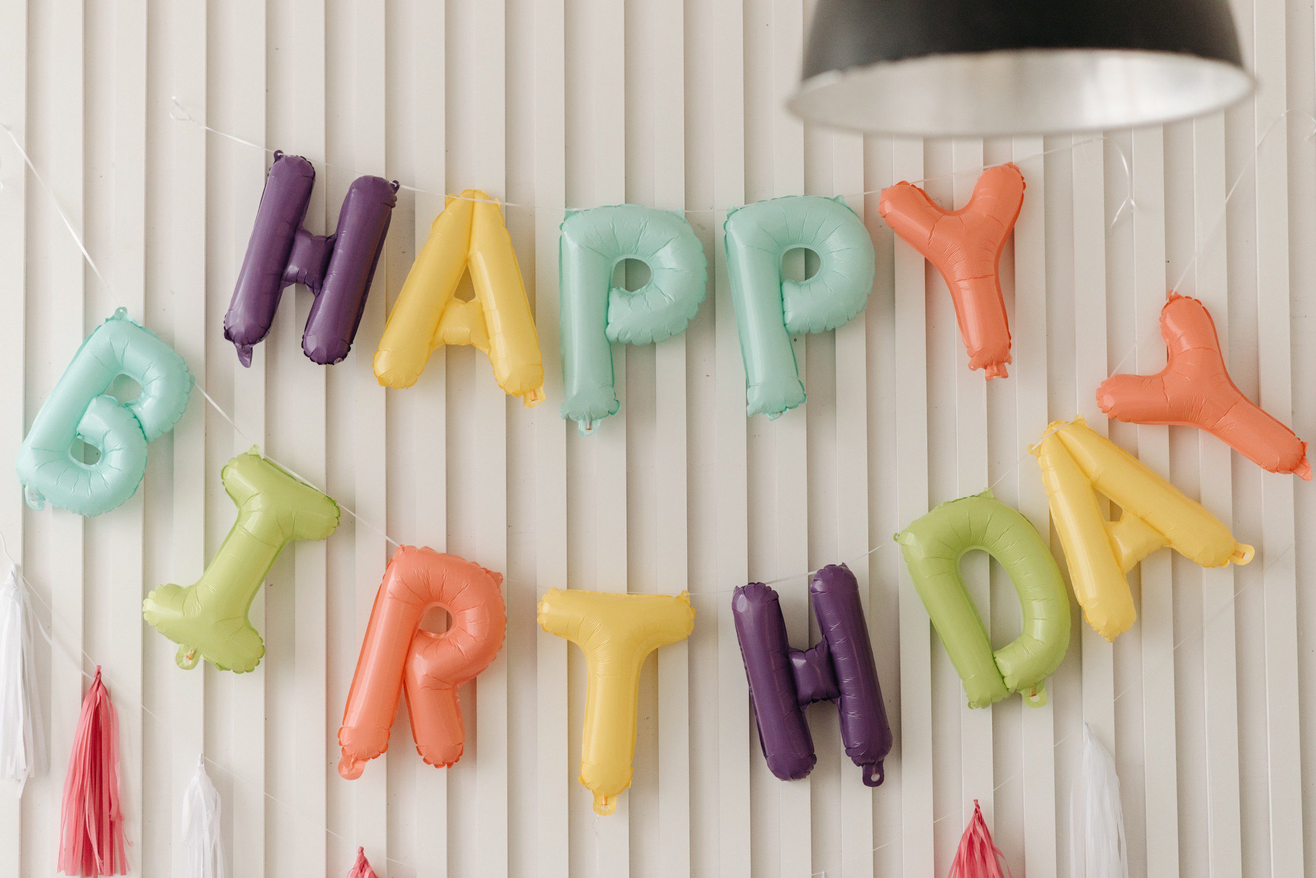 Imagem de balões coloridos com a escrita de “Happy Birthday” ou em português “Feliz Aniversário”. 