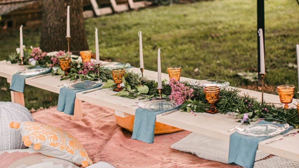 mesa posta com várias almofadas coloridas e decoração de noivado temática no ambiente externo