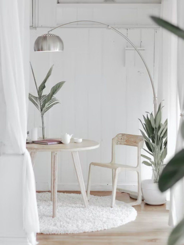 sala de jantar em branco minimalista com plantas e luminária