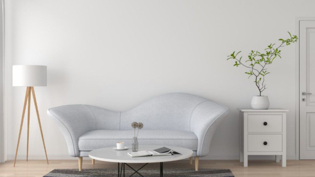 sala com decoração minimalista com sofá e mesa de cabeceira brancos e mesa de centro