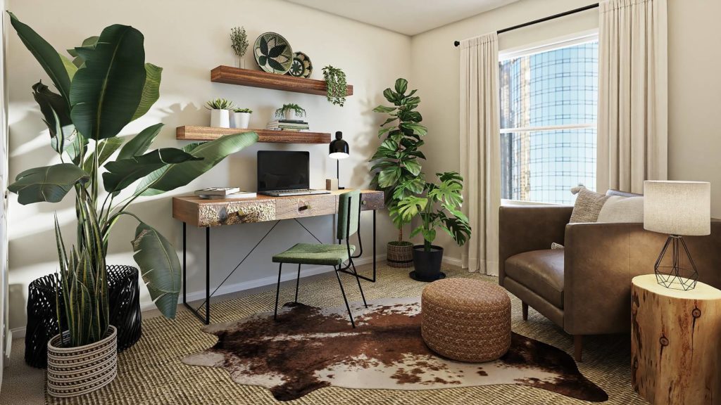 Foto de um escritório em casa com escrivaninha, cadeira, poltrona para descanso, abajur, tapete e plantas de diferentes tamanhos.  