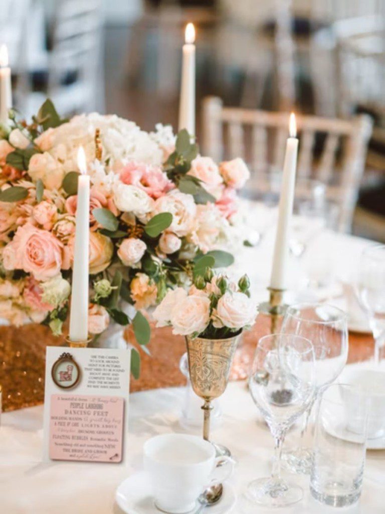 decoração de chá de cozinha com tema definido, mesa posta com flores rosas, velas, pratarias e cristais finos