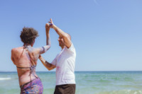 Foto que ilustra quiz de casal para o Dia dos Namorados mostra um casal dançando na praia, representando um casal que gosta de praia e samba