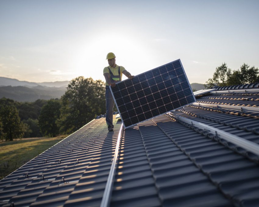 Imagem de um homem fazendo instalação de painel solar.