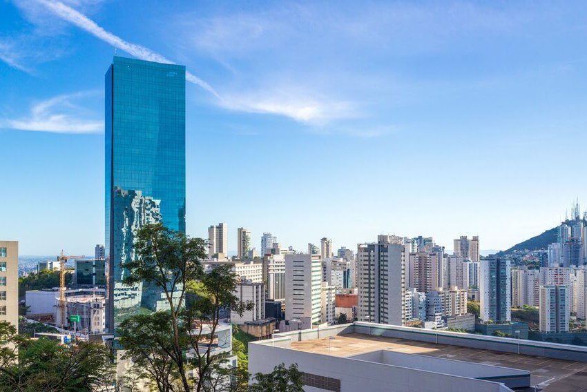 Foto que ilustra matéria sobre as melhores cidades de Minas Gerais mostra uma panorâmica de prédios da cidade de Nova Lima, com destaque para um grande edifício, mais alto, totalmente espelhado