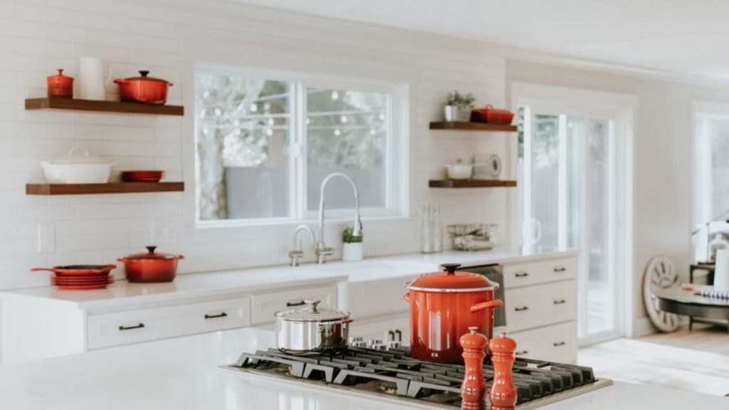 cozinha branca com utensílios vermelhos em conceito aberto
