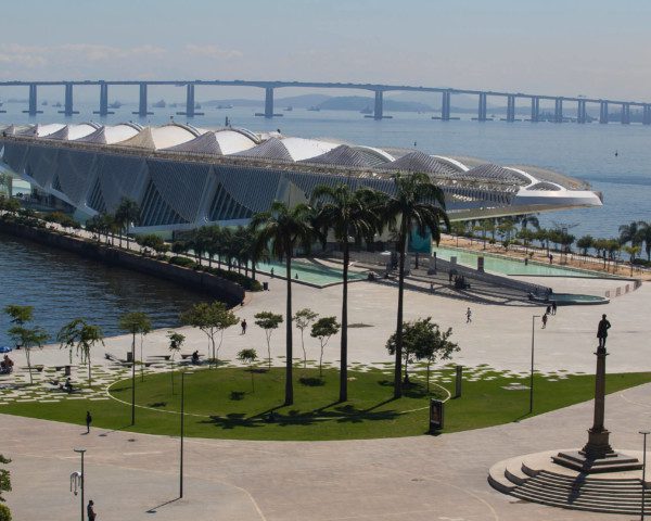 Foto que ilustra matéria sobre as melhores cidades do Rio de Janeiro mostra o Museu do Amanhã visto do alto, com a Ponte Rio-Niterói ao fundo.