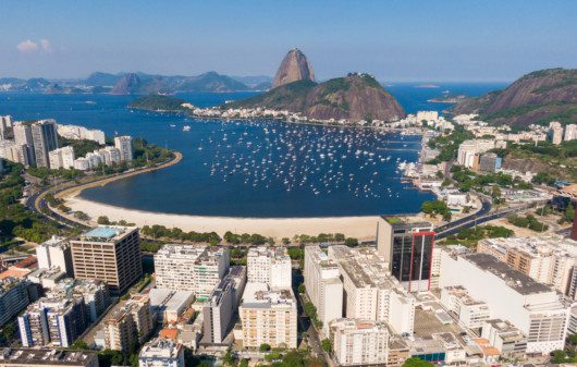Imagem que ilustra matéria sobre melhores cidades do Rio de Janeiro mostra a cidade do Rio com vista áerea para a praia e o corcovado.
