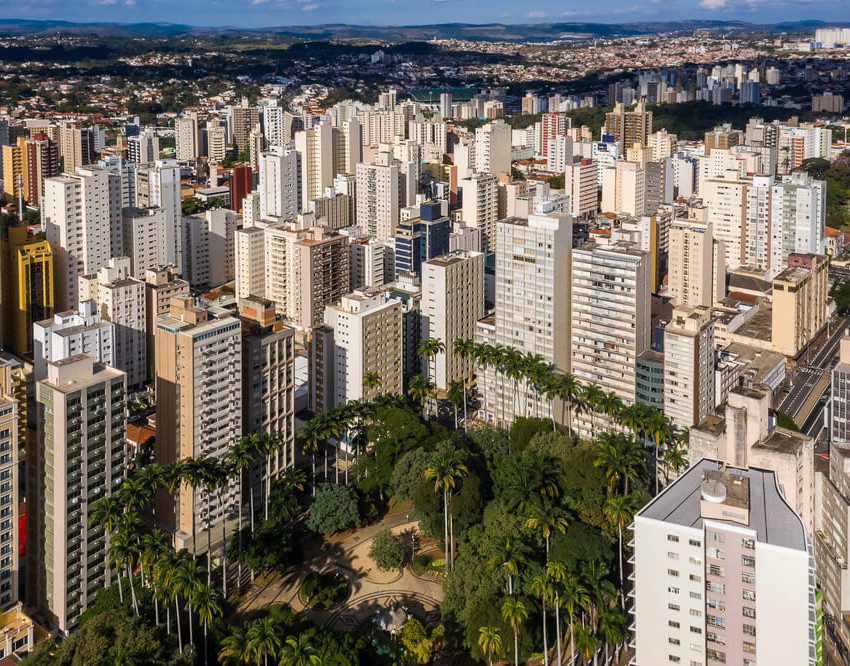 Foto que ilustra matéria sobre o custo de vida em Campinas mostra uma pequena praça arborizada, que é o centro da parte inferior da imagem, vista do alto e cercada de grandes prédios.