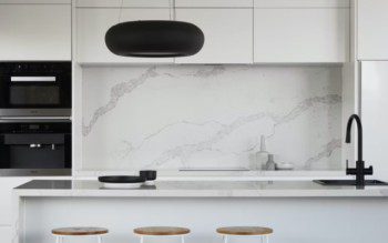 parede de pedra, bancada e armário suspenso em cozinha moderna