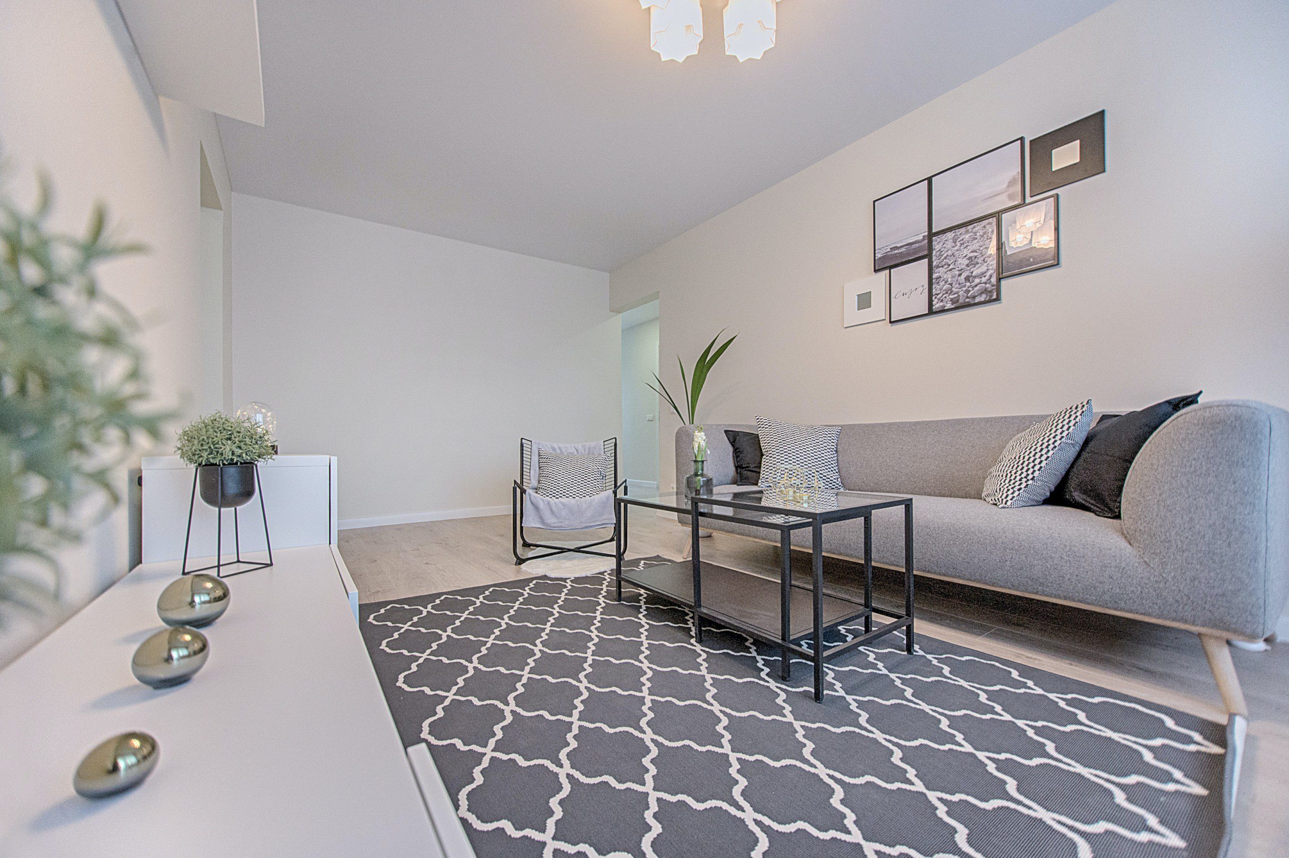 Imagem de uma sala de estar com tapete cinza estampado com decoração minimalista.