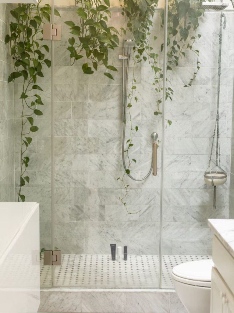 área do chuveiro de um banheiro com plantas verticais, formando um pequeno jardim