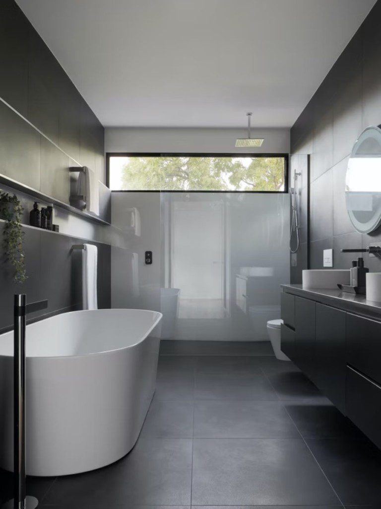 banheiro moderno com banheira e pia, e tons em branco e preto