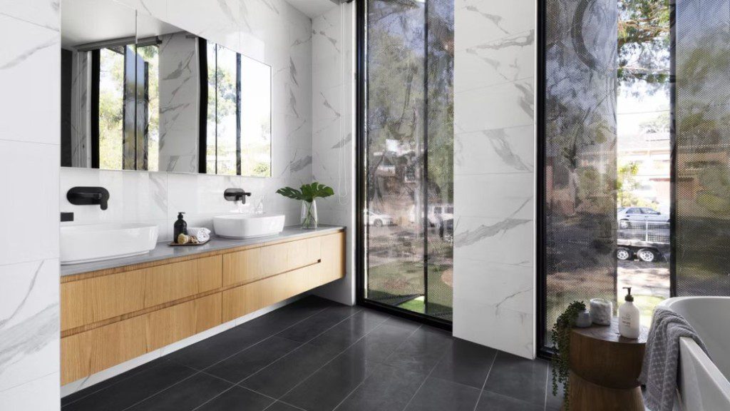 banheiro amplo com cubas de vidro e móvel de madeira