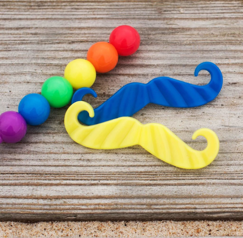 Foto que ilustra matéria sobre decoração para dia dos pais mostra bolinhas coloridas e bigodes coloridos feitos de EVA.