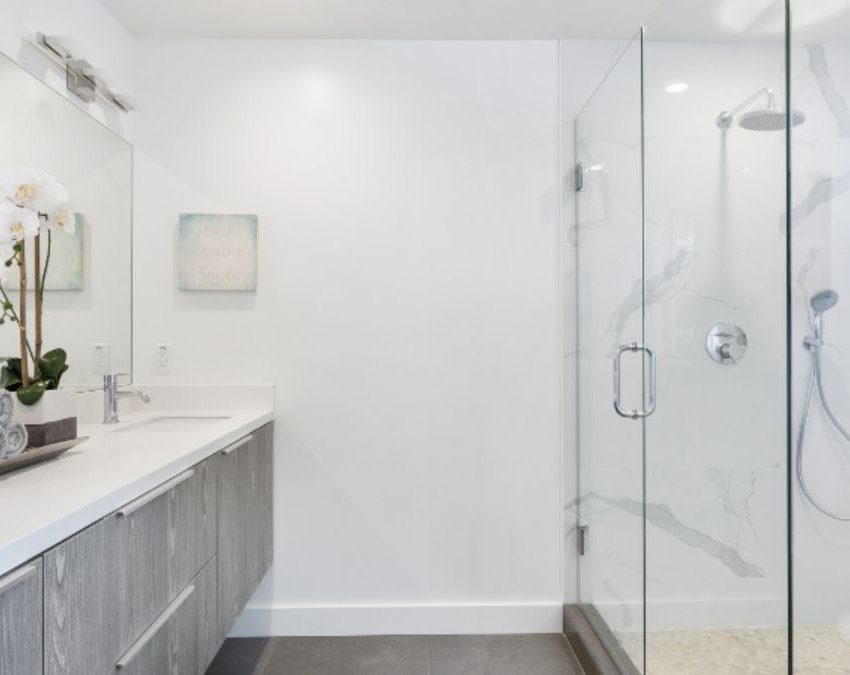 banheiro grande com paredes brancas, móveis claros e boa decoraçao