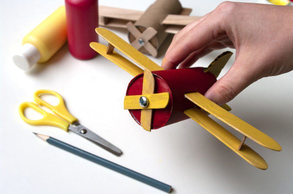 Imagem de uma aviao feito com rolo de papelao e palitos. 