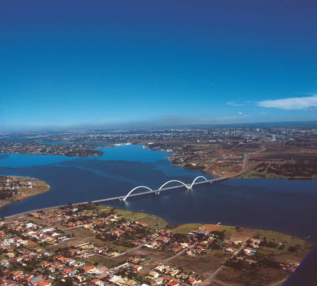 Imagem aérea do Lago Paranoá do Lago Paranoá, em Brasília, onde é possível visualizar casas, prédios e a Ponte JK, uma das opções de lazer na hora de escolher o que fazer em Brasília 
