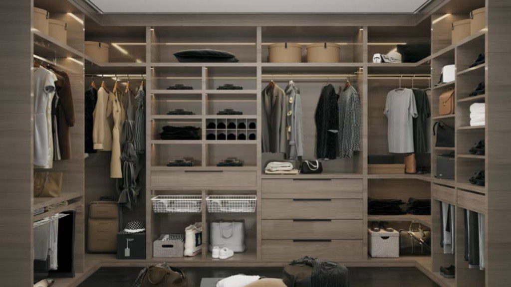 closet com armário em todas as paredes, com algumas gavetas fechadas e uma ampla seleção de roupas