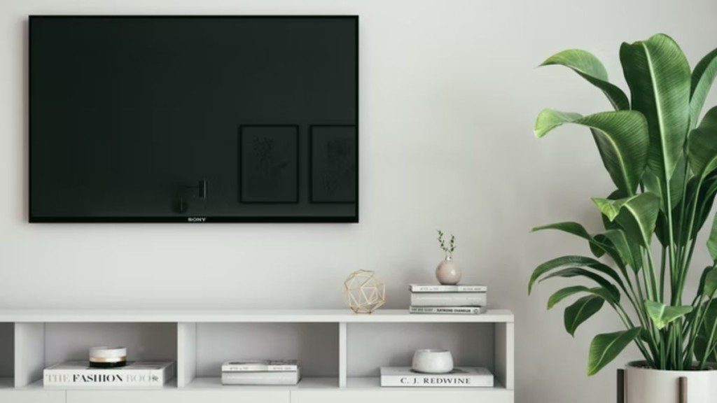 tv em painel na parede sobre um rack pequeno branco
